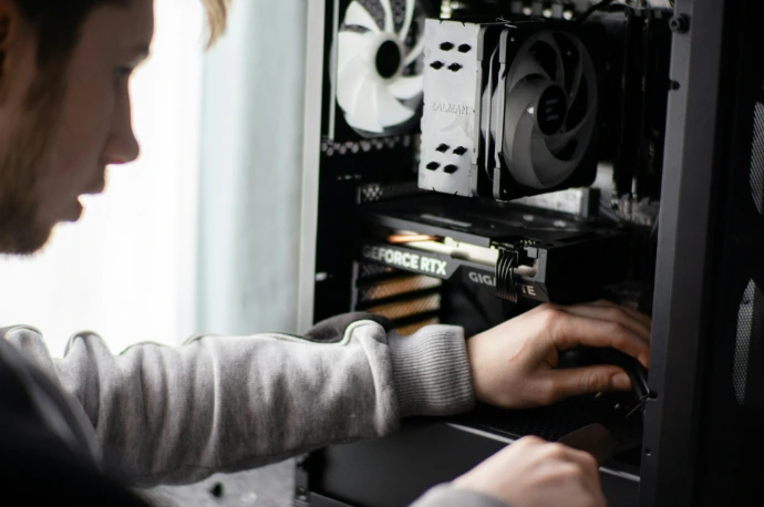 A man is working on a computer in a room
